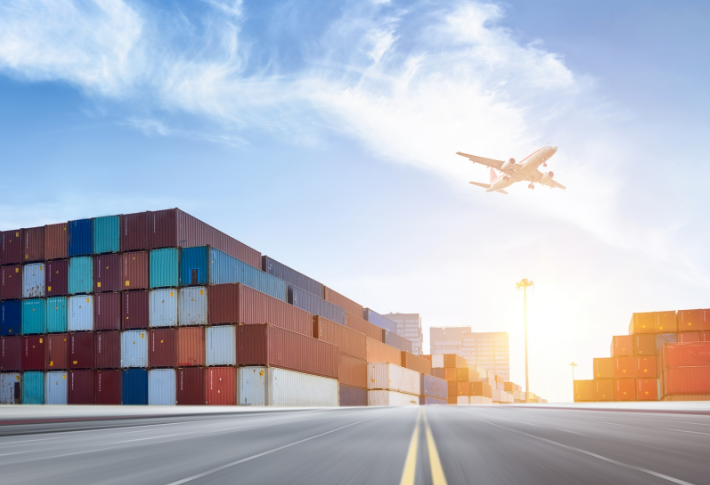 Airplane flying over shipping yard